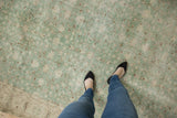 Distressed vintage Turkish Sparta carpet texture with dusty mint green, ivory floral vinery, and visible foundation.