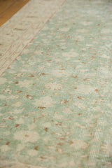 Distressed Sparta carpet pile reveals foundation and faded mint green florals.