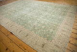 Distressed vintage Sparta carpet border showing floral vinery in dusty mint green and ivory.