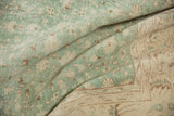 Distressed Sparta carpet fold: mint green and ivory floral patterns, foundation visible.