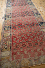 An angled view showing the repeating floral cross-sections and color variations of this long distressed Oushak runner.
