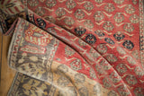 A vintage Oushak runner folded to show its madder red pile and the hand-knotted reverse weave.