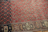 Abrash detail on a vintage Oushak rug showing floral motifs shifting from jet black to oxidized silver.