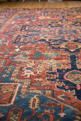 Intricate geometric floral motifs on a Vintage Karaja carpet, featuring cherry red and sapphire blue hues.