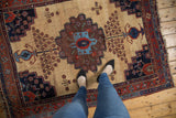 Antique Afshar rug with central stepped medallion, geometric florals, ivory ground, and mostly even wear.