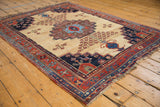 Antique Afshar rug detail: stepped aubergine medallion on ivory ground with tree-of-life motifs.