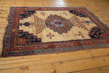 Antique Afshar rug corner detail: geometric red and blue borders, aubergine spandrel, ivory ground.