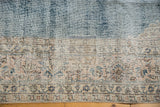 Distressed Sparta carpet detail, worn denim blue field, exposed foundation, and faded beige border.
