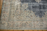 Distressed vintage Turkish Sparta carpet close-up; ivory, dusty rose border and dark navy field with visible wear.