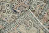 Distressed vintage Sparta carpet folded corner, showing low pile, visible foundation, selvage, and fringe.