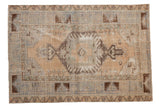 Vintage Distressed Oushak rug, central medallion with ram's horn designs, beige, faded blue.