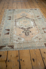 Vintage distressed Oushak rug displaying contrasting faded denim blue, beige, and chocolate brown patterns.