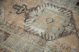 Textured pile of vintage distressed Oushak rug, with faded blue and brown ram's horn motifs.