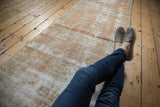 Distressed Oushak rug with low pile, visible foundation, and subtle terracotta, beige design.