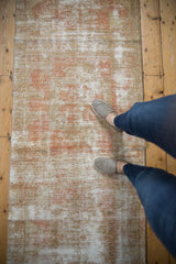 Distressed Oushak runner with faded terracotta tones and visible foundation.