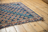 Antique Caucasian rug corner: rich ruby red, ivory, and sapphire geometric border.