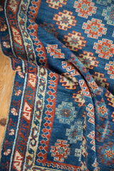 Vibrant sapphire blue and ruby red geometric patterns on antique Caucasian rug's folded field and border.