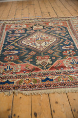 Antique Afshar carpet's dusty teal field showing serrated leaf motifs, terracotta details, and varied pile.