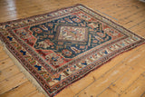 Corner view of antique Afshar carpet with terracotta, ivory geometric borders and teal field.