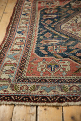 Fringed edge of antique Afshar carpet, displaying geometric patterns, terracotta and navy tones, and textured knot heads.