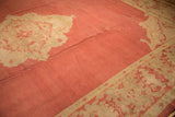 Vintage Oushak rug's serrated leaf border in antique ivory, dust brick red field with abrashes.