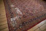 Mahal carpet's dusty cherry red henna pattern with navy accents and visible foundation wear.