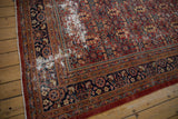 Vintage Mahal carpet corner with navy border, dusty cherry red field, and exposed foundation.