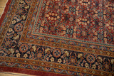 Vintage Mahal rug detail: navy border, blush and saffron motifs, and worn red henna plant field.