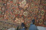 Antique Sultanabad rug detail: rust field with floral palmettes, vinery, dusty emerald green border.