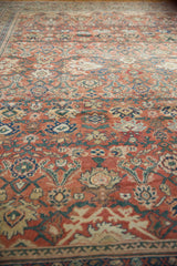 Antique Sultanabad rug: detailed floral palmettes in rust, ivory, blue, and dusty emerald border.