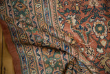 Antique Sultanabad carpet's intricate floral field in pale rust, bordered by dusty emerald green.