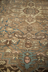 Distressed Karaja carpet detail showing geometric tendrils in soft blue, ivory, and coffee brown.