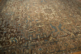 Corner of distressed vintage Karaja rug, geometric tendrils, serrated motifs in muted brown and dusty blue.