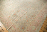 Distressed vintage Sivas carpet, with blush pink border, silver field, and delicate floral vinery.