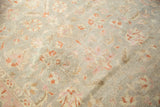 Distressed vintage Sivas carpet with faint foundation showing through blush pink and cinnabar floral vinery.