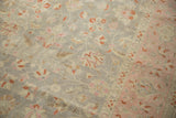 Textural detail of distressed Sivas carpet: oxidized silver field, blush border, cinnabar floral vines.