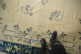 Antique ivory Peking rug field with delicate cobalt blue roses and vinery, subtle pile texture.