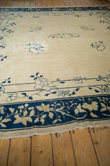 Antique Peking rug with rich indigo border, ivory vinery, and delicate blue field motifs.