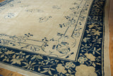 Antique Peking rug detail: indigo blue border with ivory floral vinery and blossomed roses.