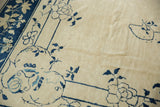 Ivory field and cobalt blue floral vinery in antique Peking rug corner, with varied pile.