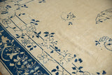 Antique Peking rug detail: intricate blue floral vinery and blossomed roses on an ivory field.