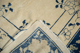 Antique Peking carpet corner showing ivory field with indigo vinery and hand-knotted reverse.