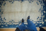 Vintage Chinese Peking rug section with ivory field, cobalt blue floral sprawling border, short pile.