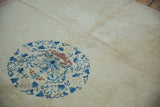 Detail of a blue floral spandrel and the even, short pile on an antique Peking carpet's ivory field.