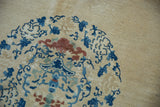 Close-up of the even, short wool pile on an antique Peking carpet with blue scrolling vinery.