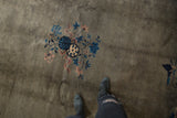 Vintage Peking carpet featuring an infinity knot, pinwheel, and blue-mauve floral vinery on a muted field.
