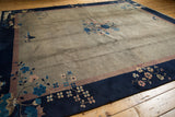 Indigo blue border of vintage Peking rug featuring dusty mauve stripe and pale floral blossoms.