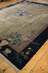 Corner detail of the vintage Peking carpet showing a pictorial vase, blue and dusty mauve blossoms, and indigo border.
