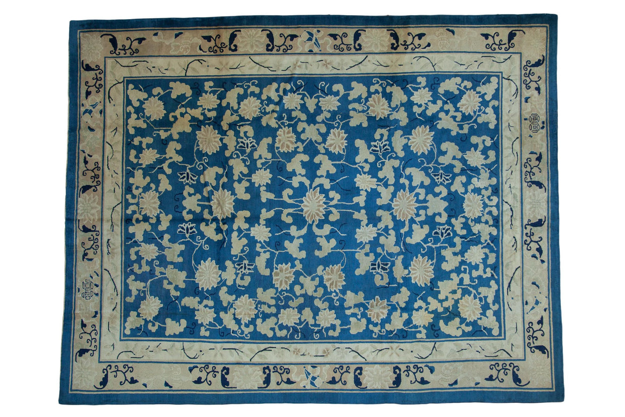 Antique Chinese Peking carpet with sprawling ivory vinery, blossoms, and cloudband motifs on sky blue.