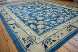 Antique Peking carpet's ivory border showing cobalt cloudband and rhinoceros horn motifs.